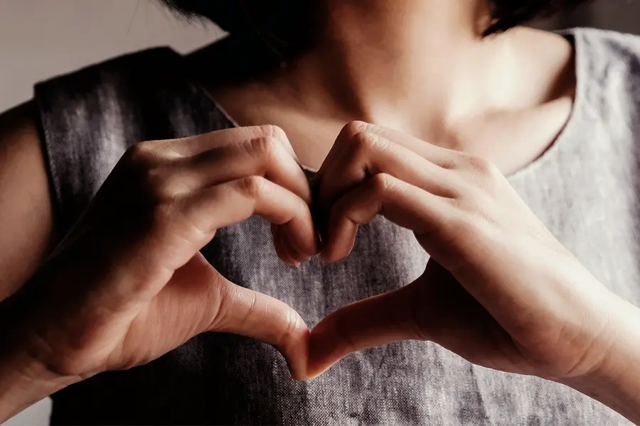 A woman makes a heart symbol with her hands. Get behavioral health and compassionate counseling from Dr. Lashea Davis Roland in Silver Spring.