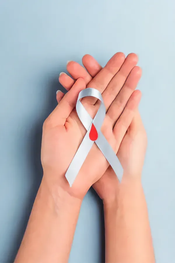 A woman's hands holding a white ribbon with a red drop symbol on it, symbolizing diabetes treatment from Dr. Lashea Davis Roland in Silver Spring.